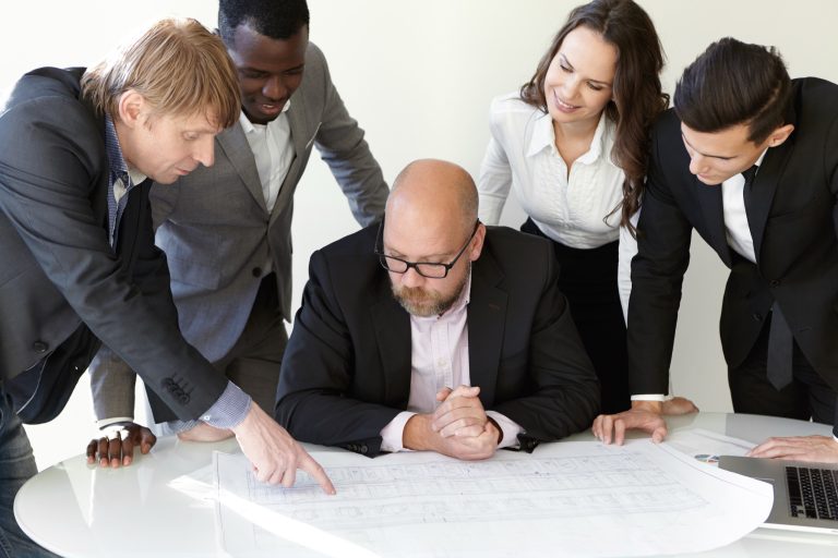 Senior professionals reviewing construction project drawings
